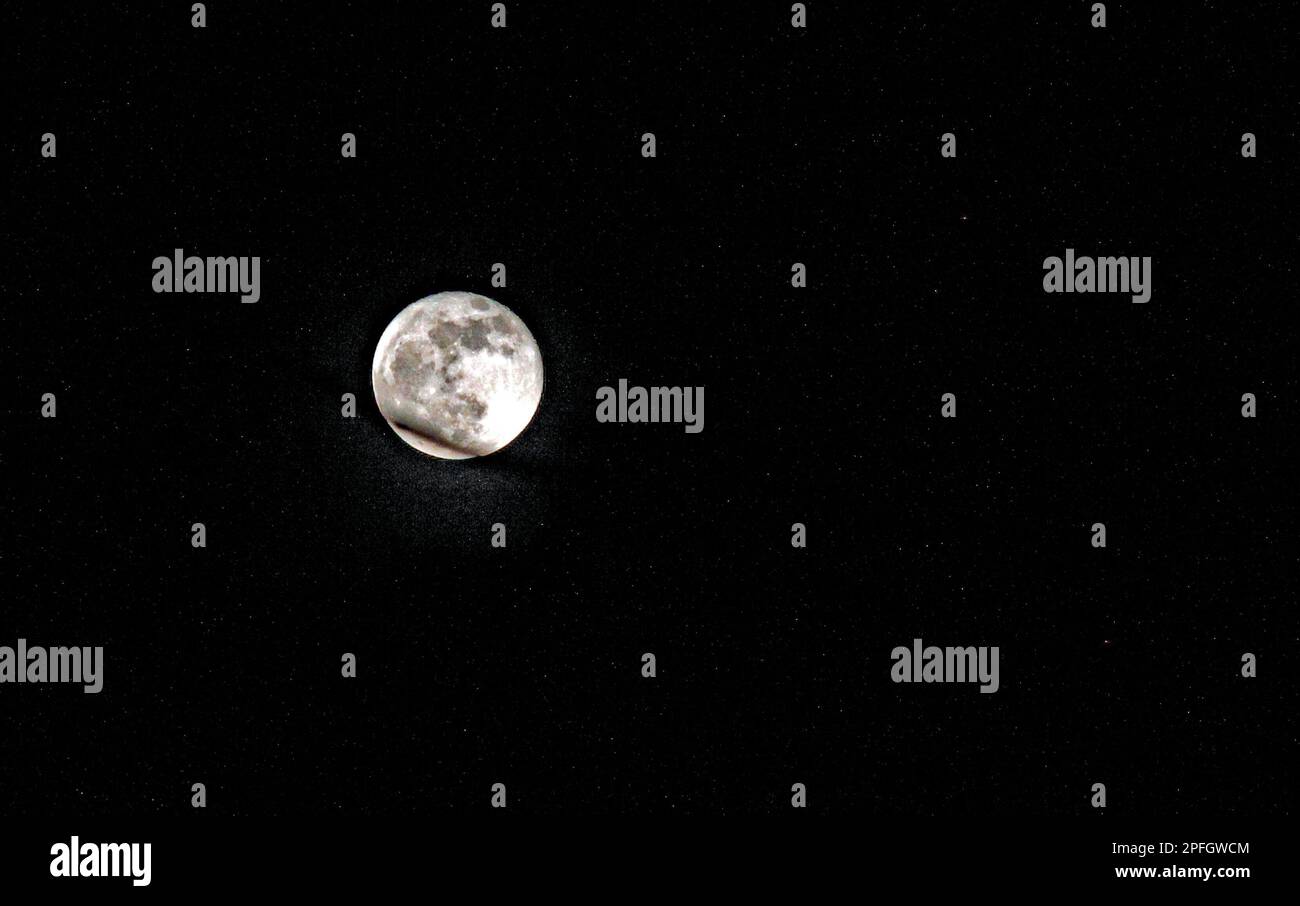 A full moon illuminates the starry night sky Stock Photo - Alamy