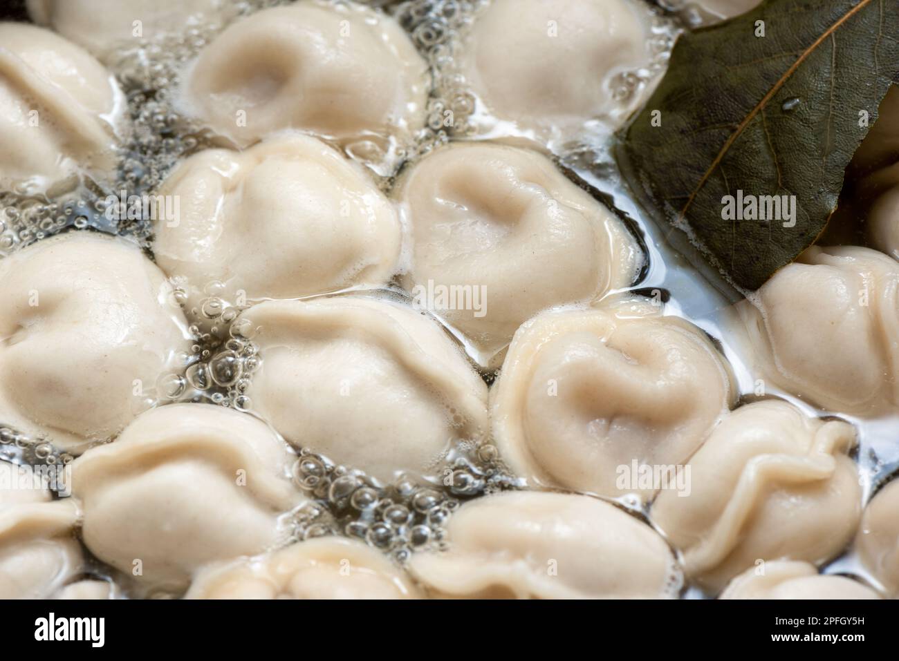 Full frame of dumplings in boiling water. Dumplings are boiled in a pot