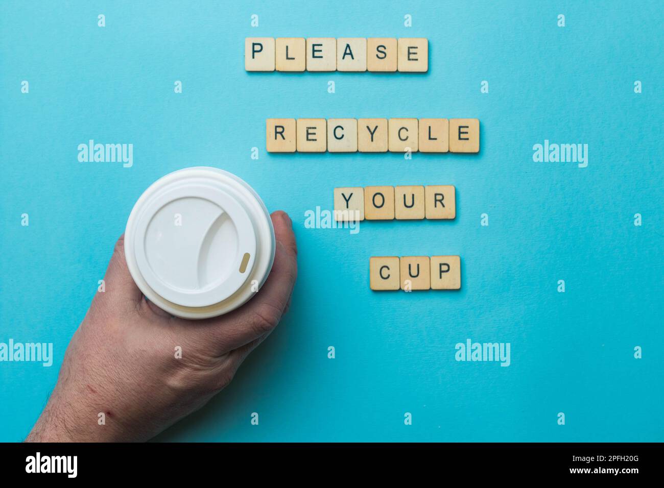 A paper coffee cup amd lid with a sign reading Please Recycle Your Cup ...