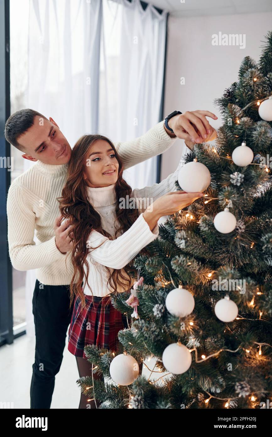 Standing near fir. Young romantic couple celebrates New year together ...