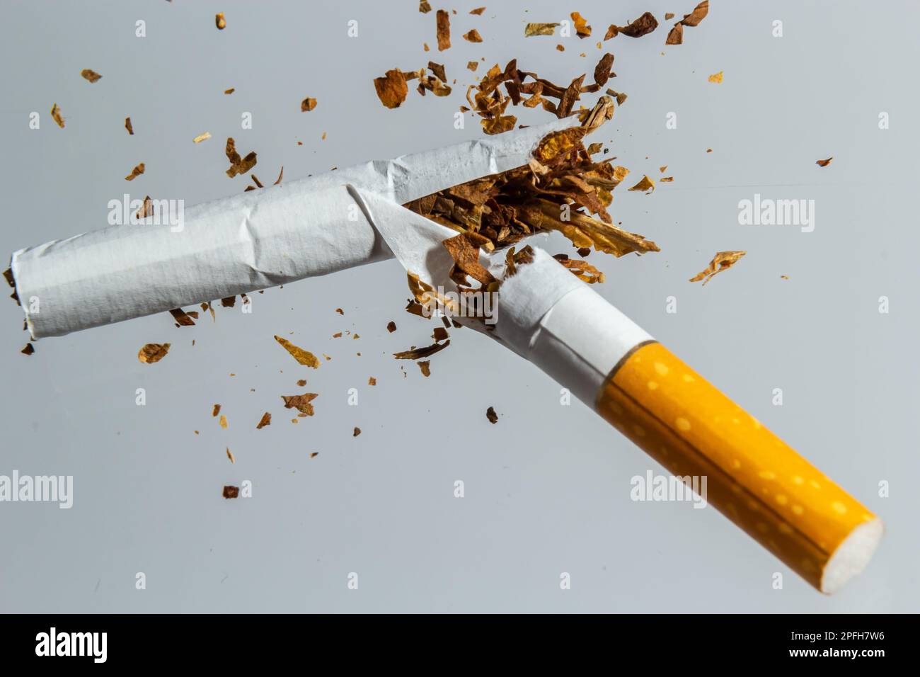 Broken cigarette fly in air on a light background. Conception of