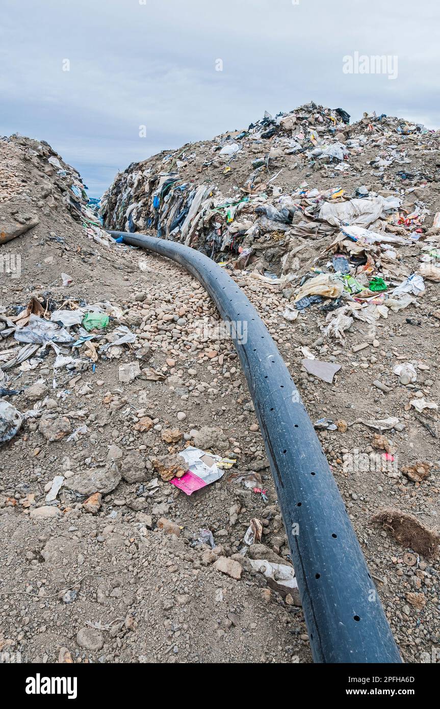 A perforated pipe for methane gas is laid in a trench to be buried in