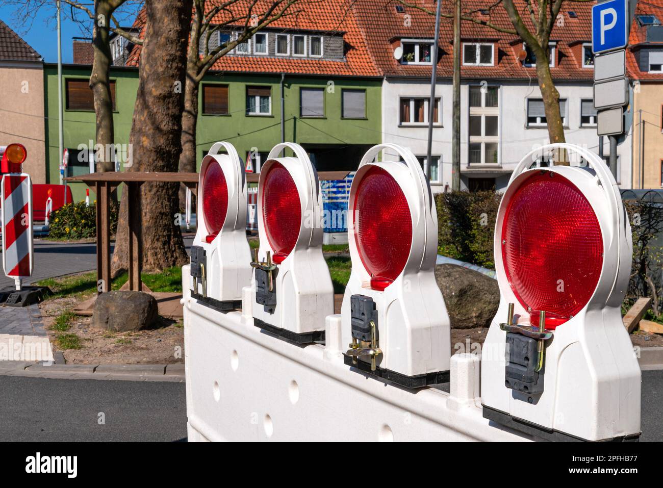 Construction plastic white barrier at a road with red reflecting lamps