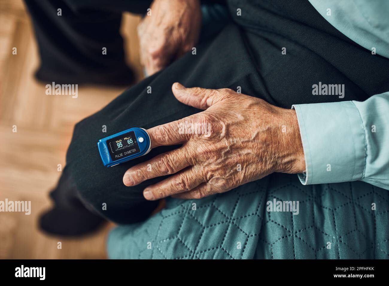 Senior man measuring the degree of oxygen saturation of the blood and