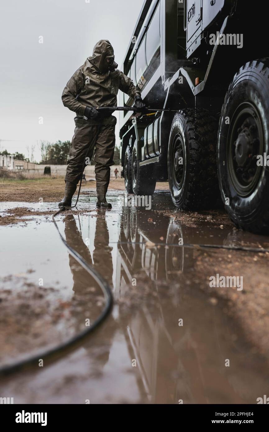 A NBC defense soldier in protective gear, pictured decontaminating a truck as part of a capability show at the Bundeswehr military base in Mahlwinkel, March 16, 2023. Recording for editorial use only! Stock Photo