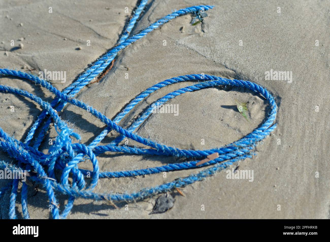 Plastic pollution. Discarded nylon rope on the beach Stock Photo