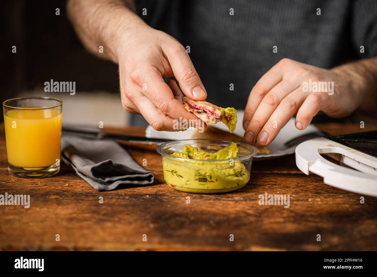 Eating A Toaster unrecognizable man eats toast with guacamole. Breakfast time. The man's ...