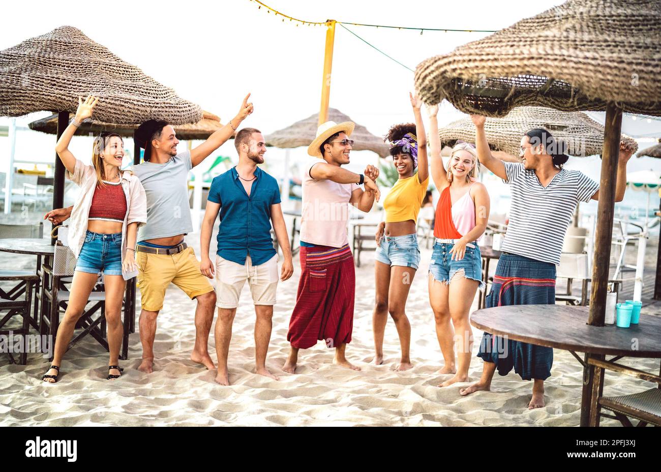 Young trendy friends dancing and having fun at chiringuito beach club - Friendship life style concept with happy people together at spring break fest Stock Photo
