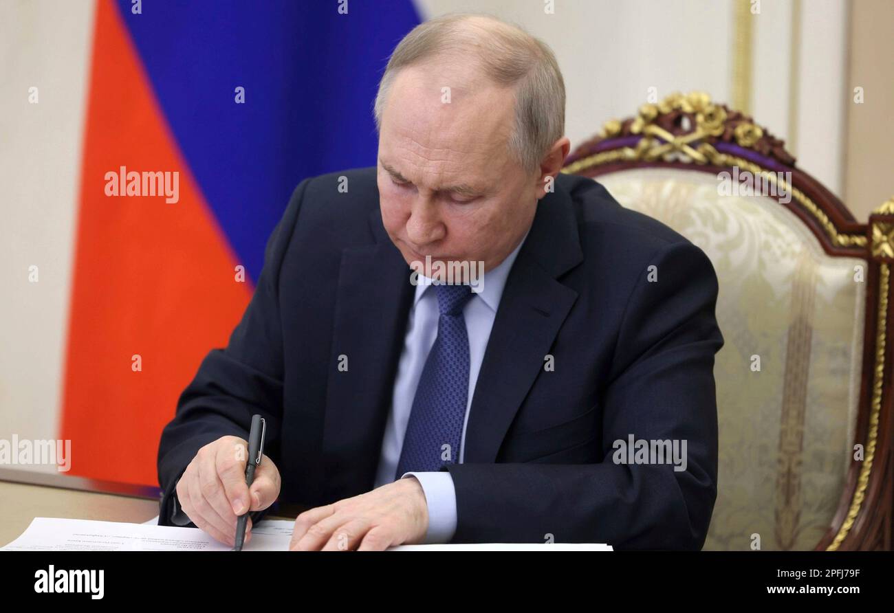 Moscow, Russia. 17th Mar, 2023. Russian President Vladimir Putin makes a note during a virtual meeting with the leaders of occupied Crimea and Sevastopol to discuss the economy from the Kremlin, March 17, 2023 in Moscow, Russia. Credit: Sergei Ilyin/Kremlin Pool/Alamy Live News Stock Photo