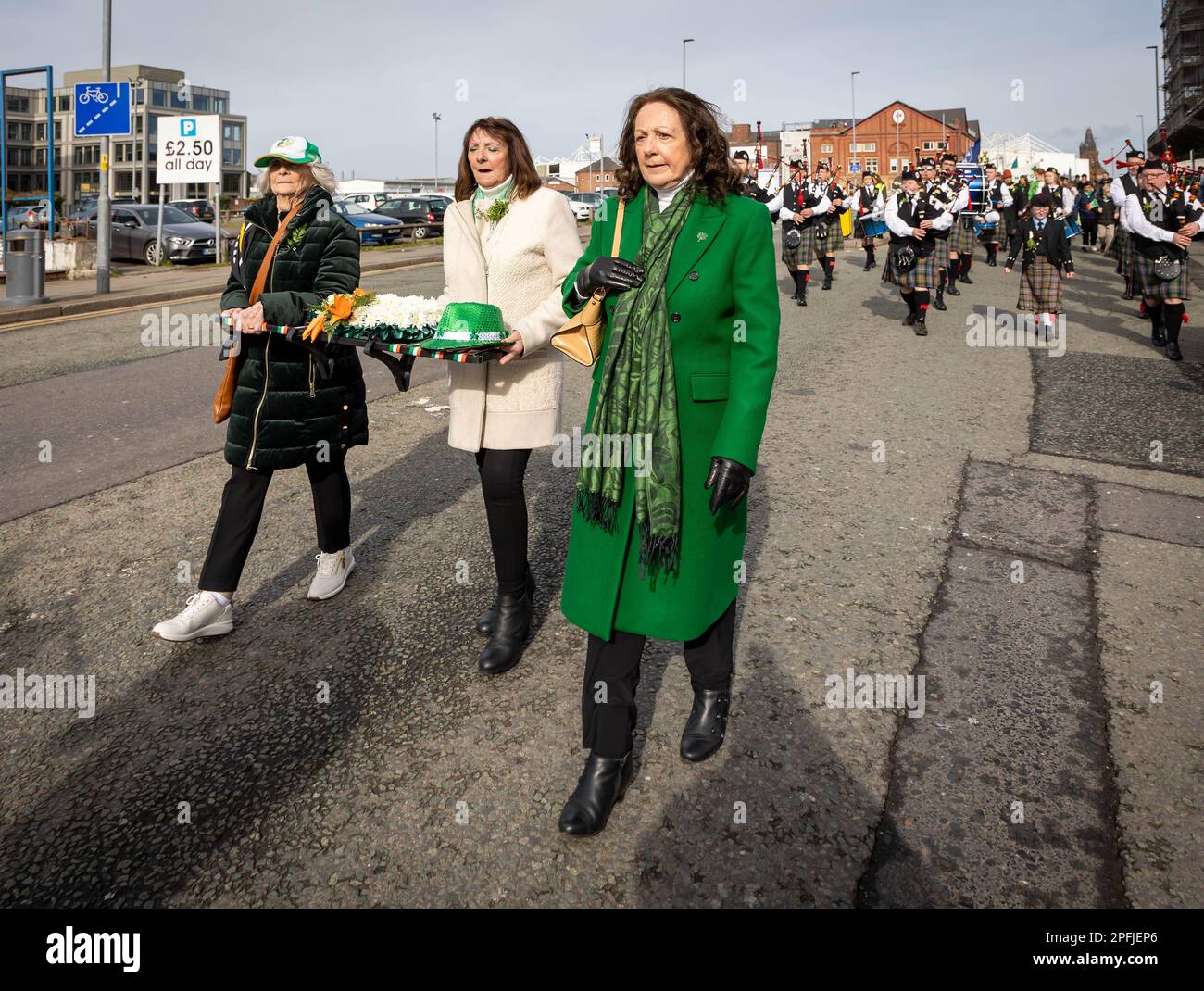 2023 St Patrick’s Day Parade in Warrington. Three ladies carry a wreath Stock Photo