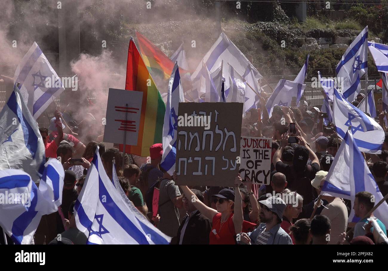 TEL AVIV, ISRAEL - MARCH 16: Anti-government protesters hold Israeli flags and let off red smoke flare as they block the Ayalon highway, one of the Israel's major freeways, during a demonstration against Israel's Prime Minister Benjamin Netanyahu's new right-wing coalition and its proposed judicial changes on March 16, 2023 in Tel Aviv, Israel. Credit: Eddie Gerald/Alamy Live News Stock Photo