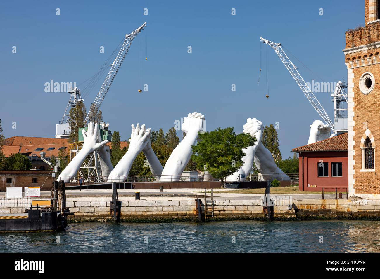 Venice, Italy - September 6, 2022: Giant joined hands sculpture Building Bridges by Lorenzo Quinn. Exhibition at Arsenale, Castello, Venice Stock Photo