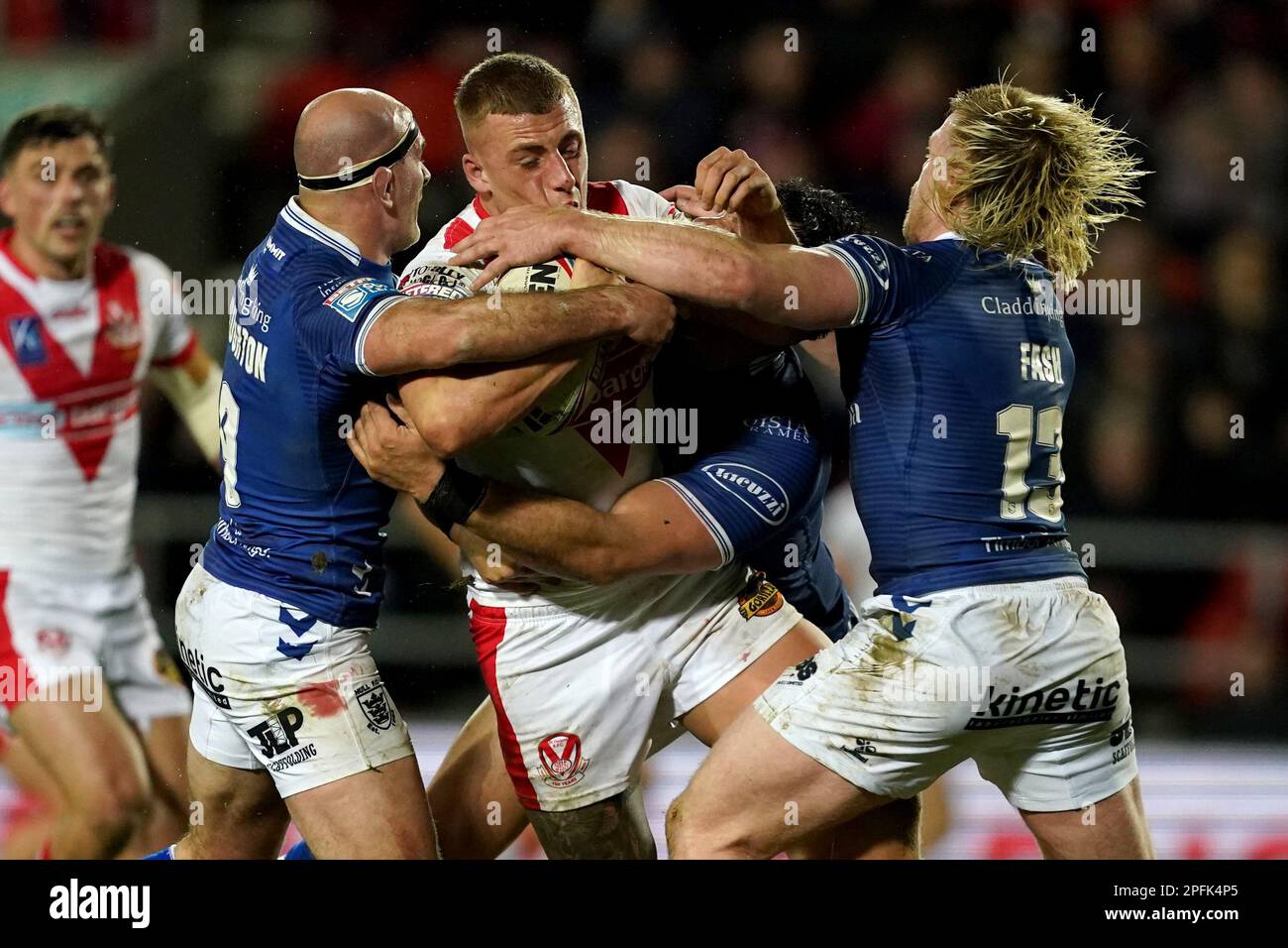 St Helens’ Joey Lussick (centre) is tackled by Hull FC’s Danny Houghton and Hull FC’s Brad Fash during the Betfred Super League match at the Totally Wicked Stadium, St Helens. Picture date: Friday March 17, 2023. Stock Photo