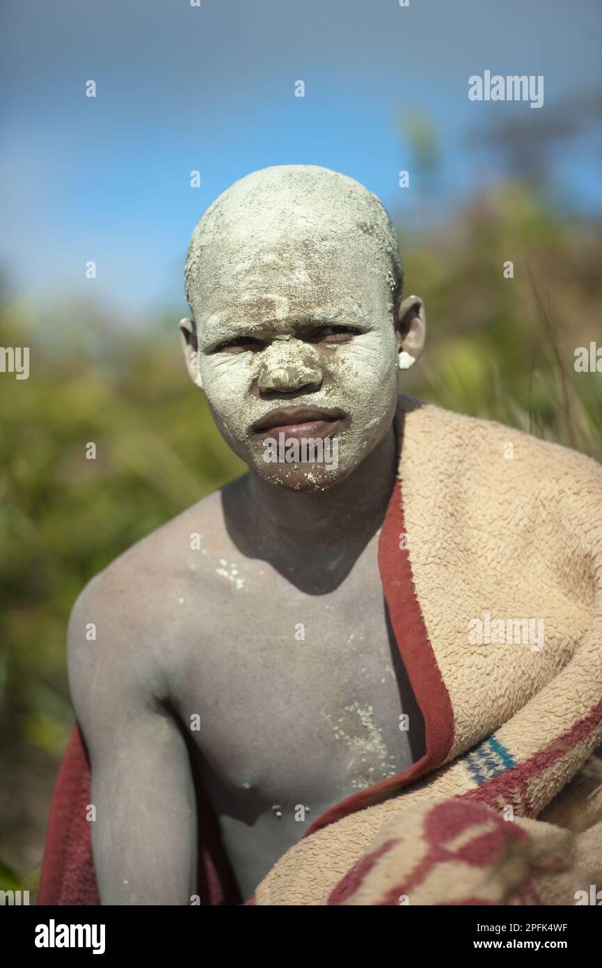 AmaPondo (Xhosa) boy wrapped in rugs with white clay (I-Futa) on face, after being circumcised (uku-Lukwa) and having finished initiation, seclusion Stock Photo