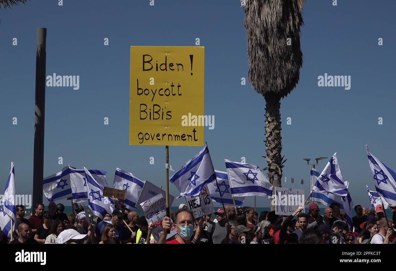TEL AVIV, ISRAEL - MARCH 16: A protester holds up a sign which reads 'Biden! boycott Bibi's government' during a demonstration held by anti government protesters in front of the U.S embassy branch calling for the U.S government to oppose Israel's Prime Minister Benjamin Netanyahu's new right-wing coalition and its proposed judicial changes on March 16, 2023 in Tel Aviv, Israel. Credit: Eddie Gerald/Alamy Live News Stock Photo