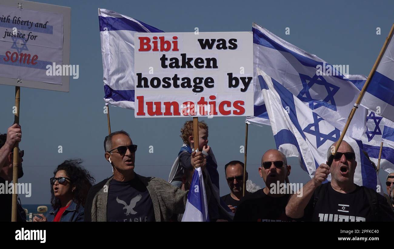 TEL AVIV, ISRAEL - MARCH 16: A protester holds a sign which reads 'Bibi was taken hostage bt lunatics' during a demonstration held by anti government protesters in front of the U.S embassy branch calling for the U.S government to oppose Israel's Prime Minister Benjamin Netanyahu's new right-wing coalition and its proposed judicial changes on March 16, 2023 in Tel Aviv, Israel. Credit: Eddie Gerald/Alamy Live News Stock Photo