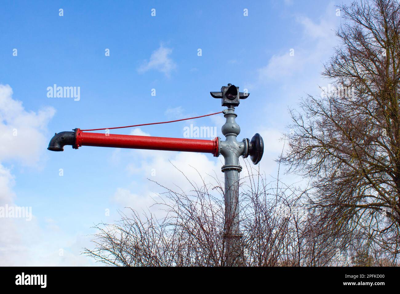 Red water faucet on the background of the sky. Fire hydrant with faucet and shut-off valve. Stock Photo