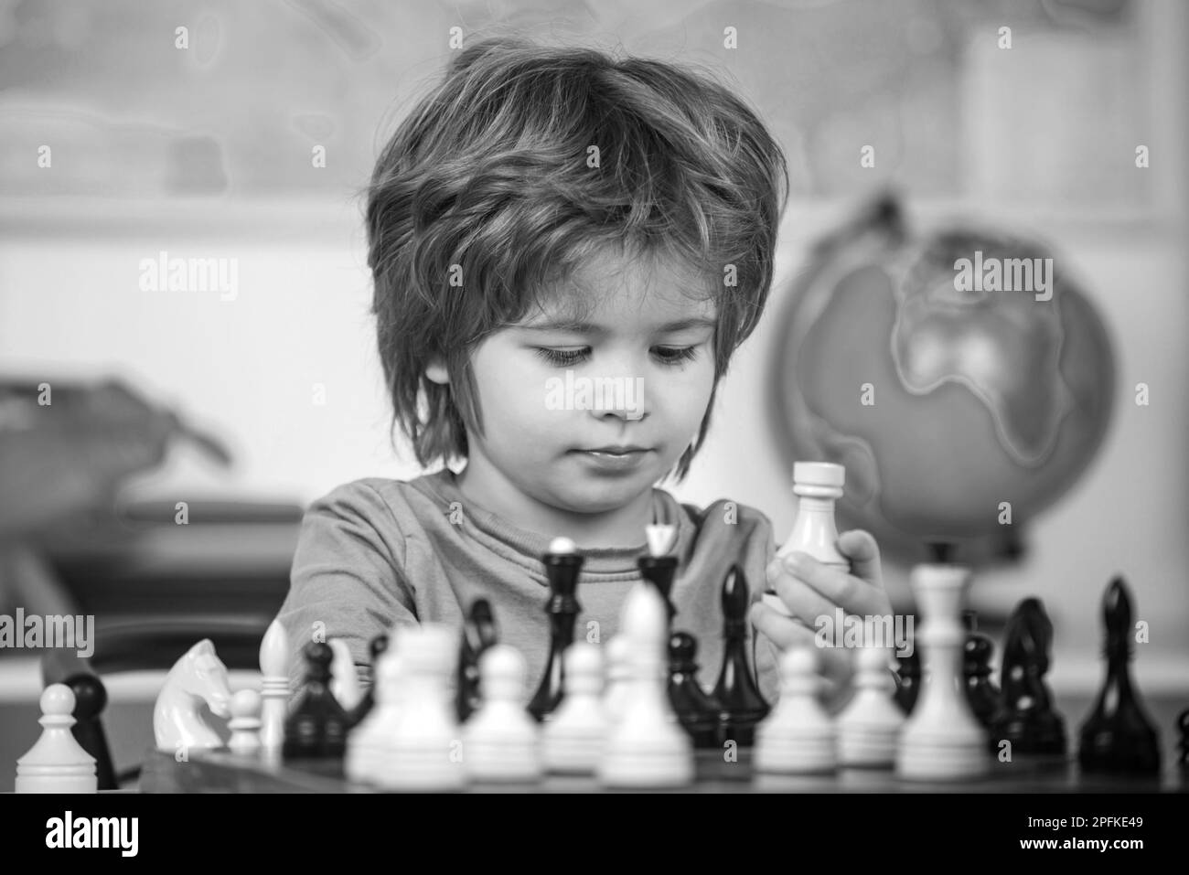 Preschooler or schoolboy, Thinking kid. Kid playing chess in the room