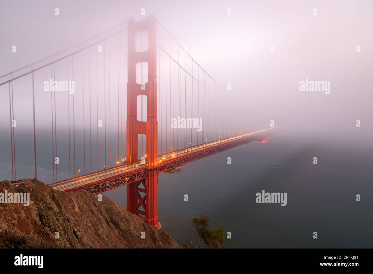 View of Golden gate bridge shrouded in thick fog at dusk in autumn Stock Photo