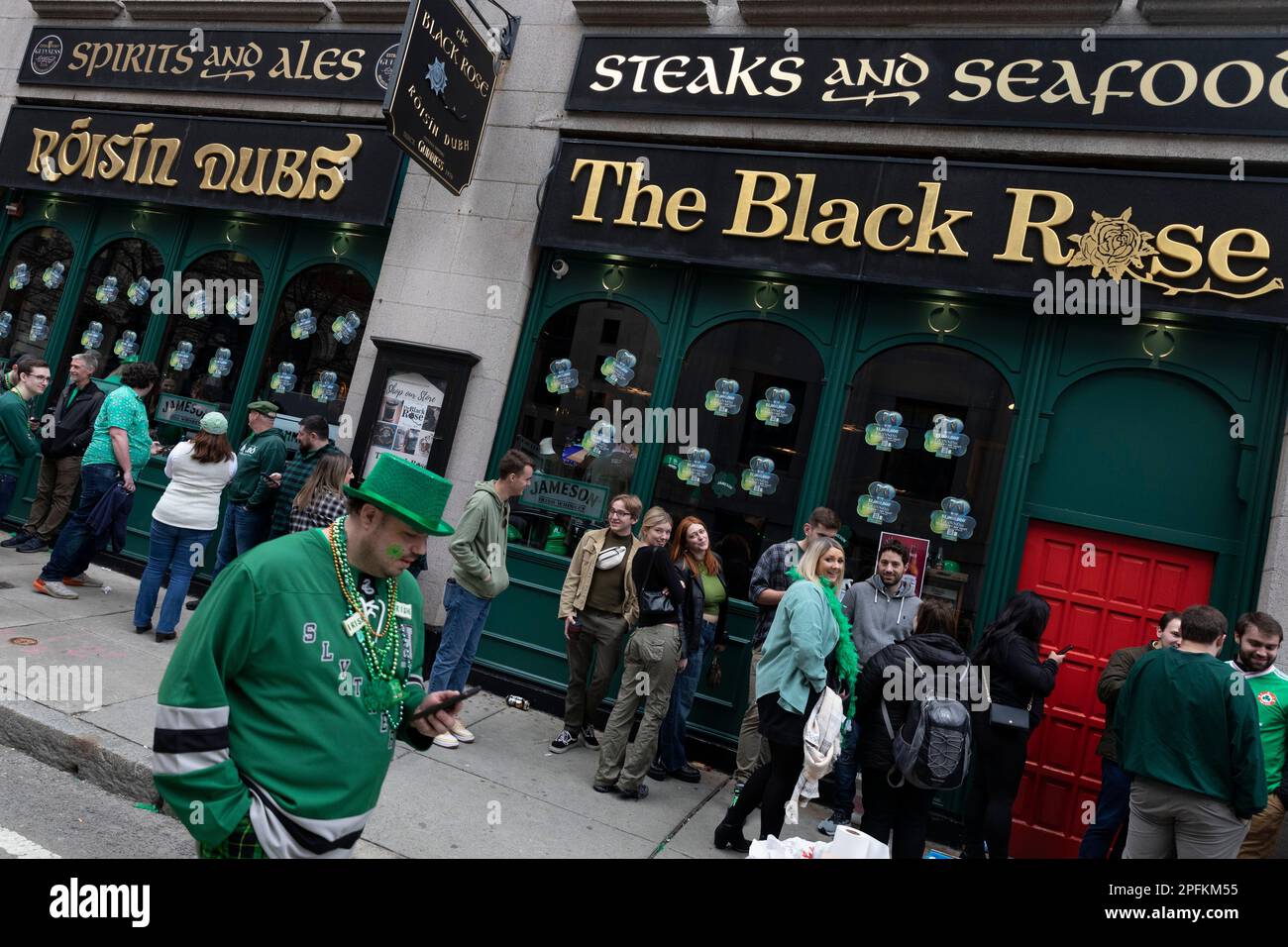 People line up to enter the Black Rose pub on St. Patrick's Day, Friday