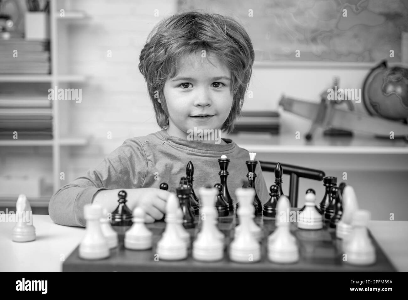 Chess strategy. Kid playing chess. Child and childhood. Clever concentrated and thinking child while playing chess. Stock Photo