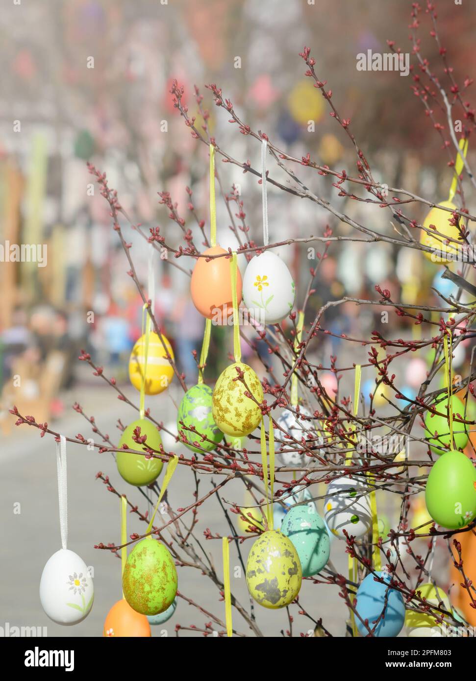 view of twigs with decorative Easter eggs on blurred background Stock Photo