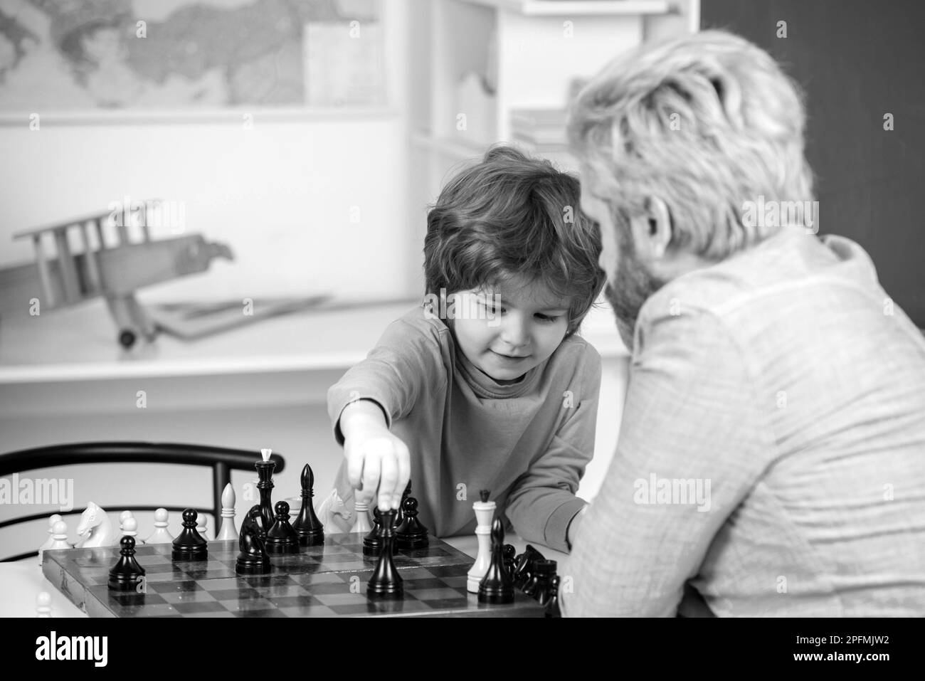 Pupil kid thinking about his next move in a game of chess. Concentrated  little boy sitting at the table and playing chess Stock Photo - Alamy