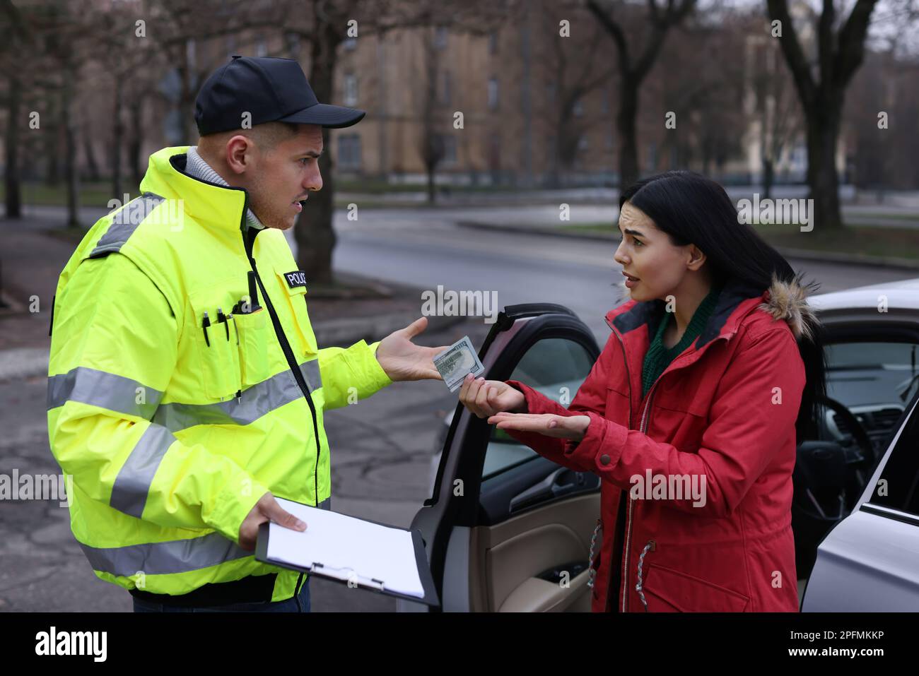 Woman giving bribe to police officer near car outdoors Stock Photo Alamy