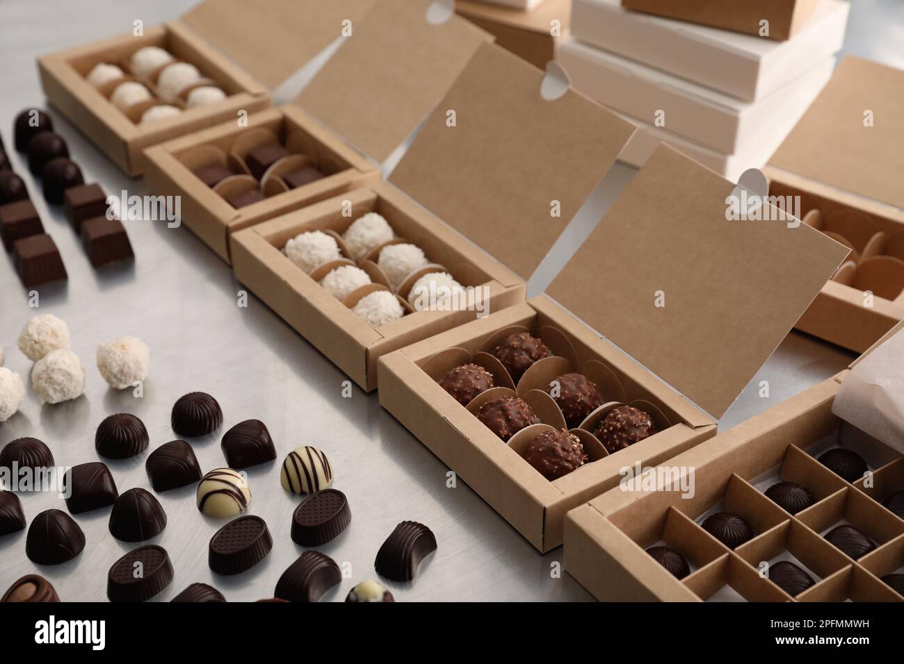 Different delicious chocolate candies and boxes on white table ...