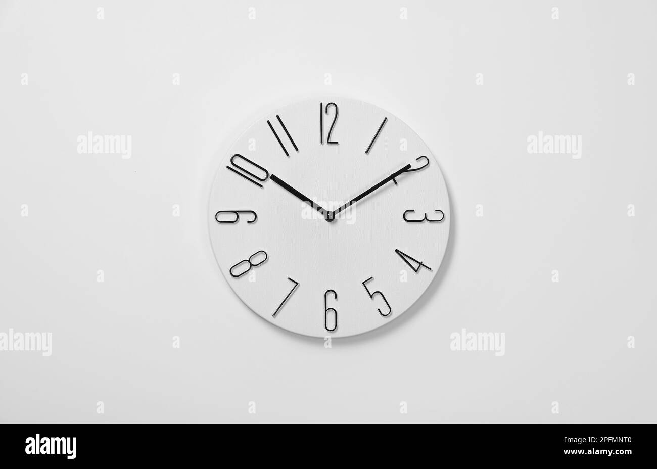Stylish analog clock hanging on white wall Stock Photo Alamy