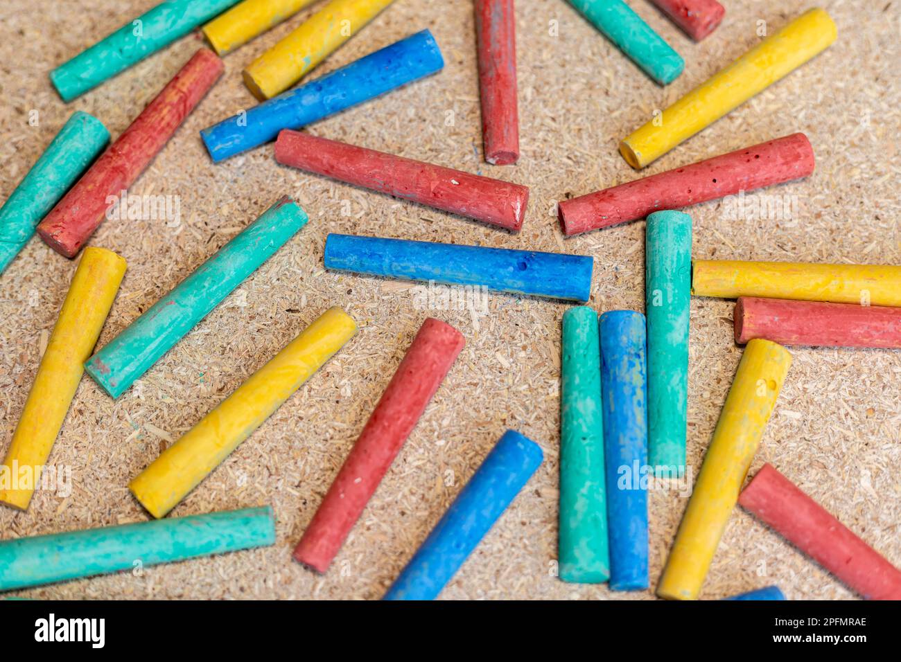 Multicolor chalks on a cork board Stock Photo