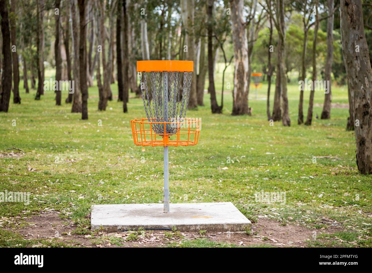 Disc golf (frolf) basket in a park obstacle course with a shallow depth of field Stock Photo