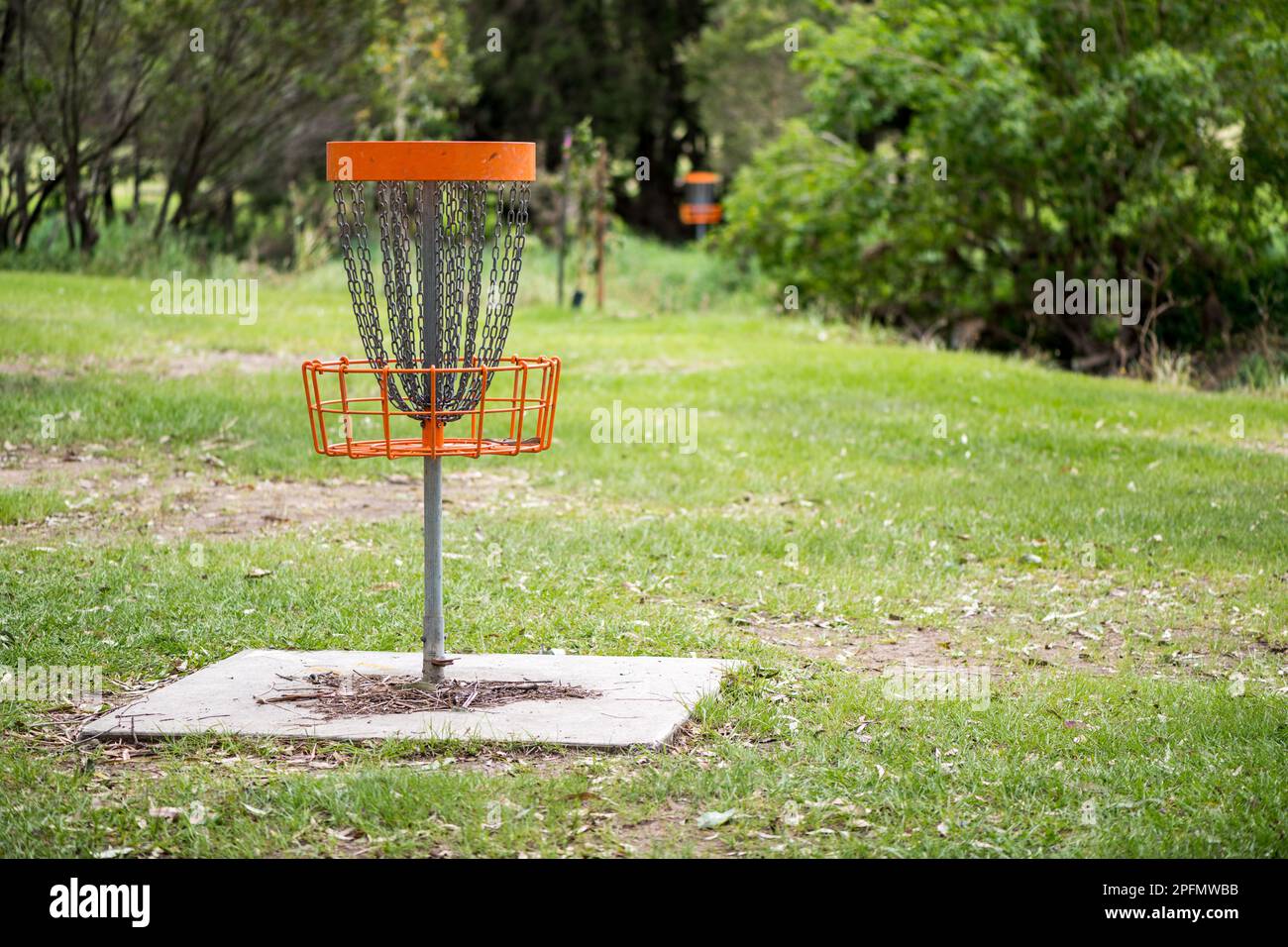 Disc golf (frolf) basket in a park obstacle course with a shallow depth of field Stock Photo