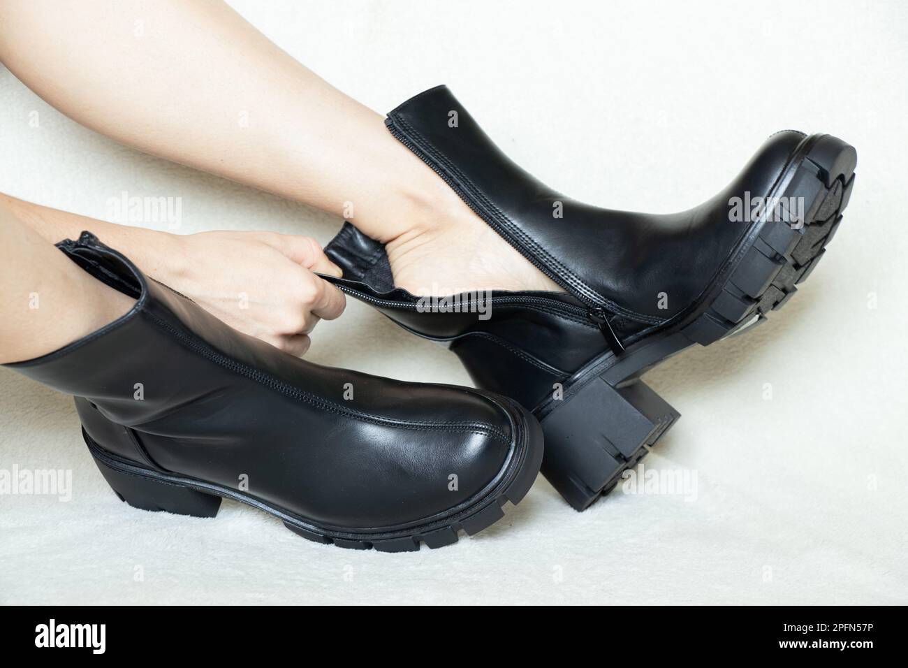 girl in high black boots on a white background, womens shoes, feet in