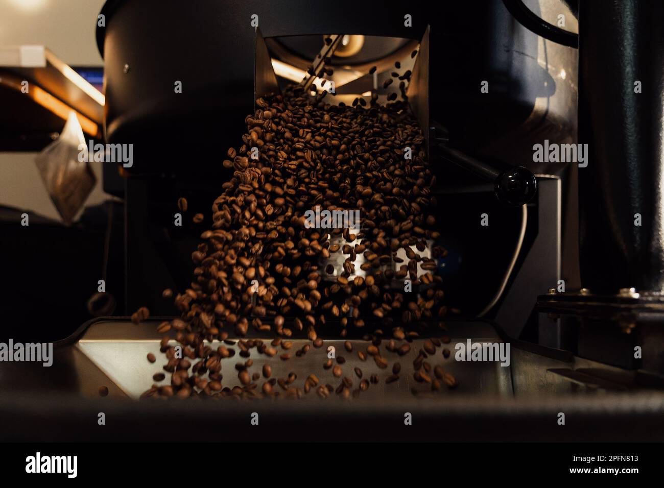 Releasing roasted coffee beans from cooling tray Stock Photo - Alamy