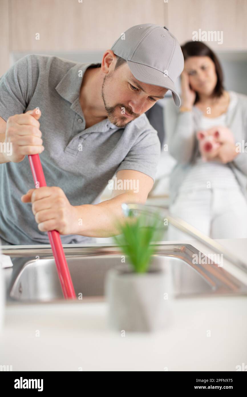 plumber unclogging a bathtube drain Stock Photo