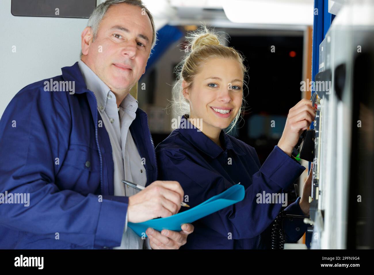man taking notes while female worker operates machines Stock Photo - Alamy