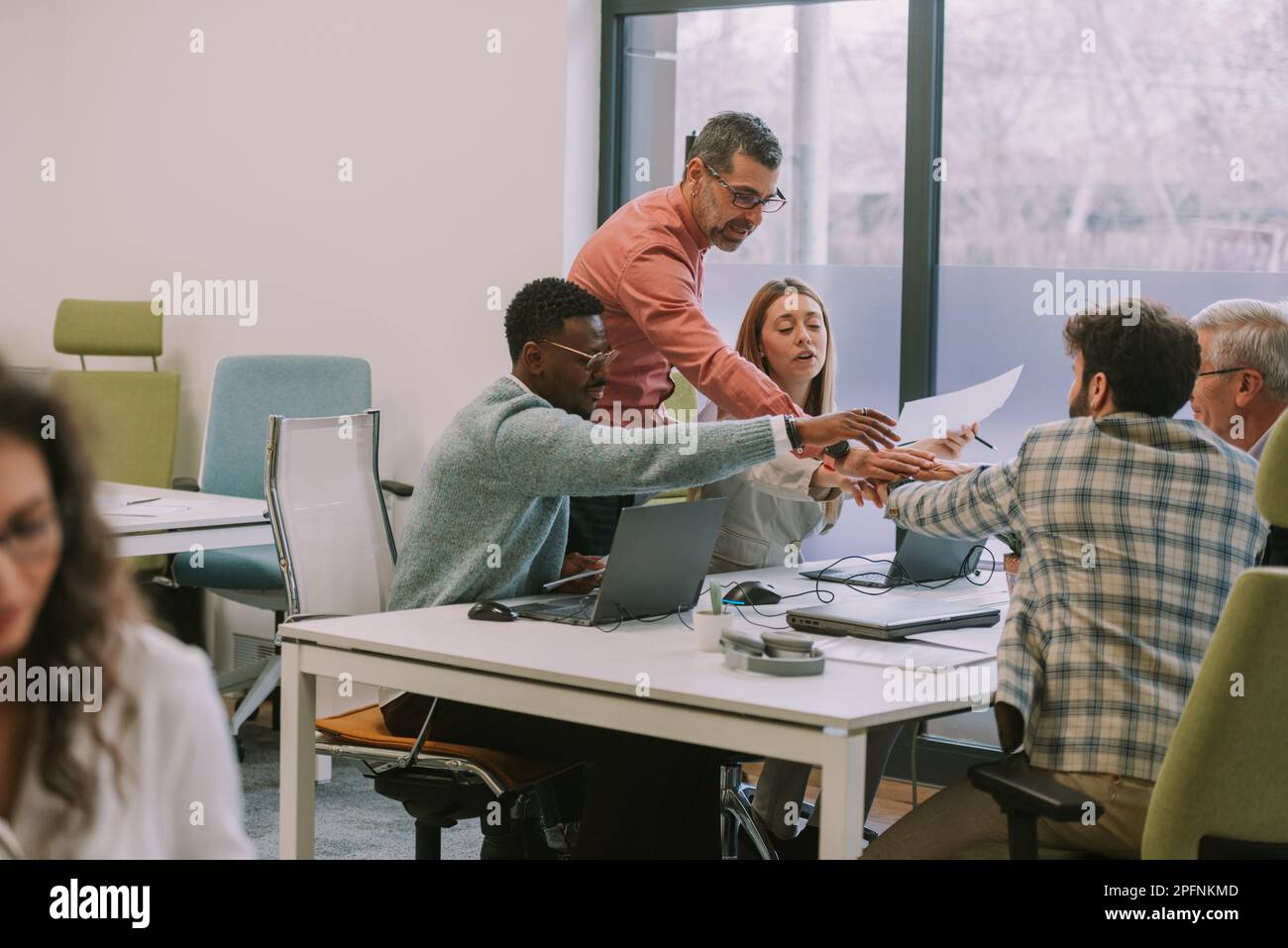 Group of business people stacking hands together at the office desk at ...