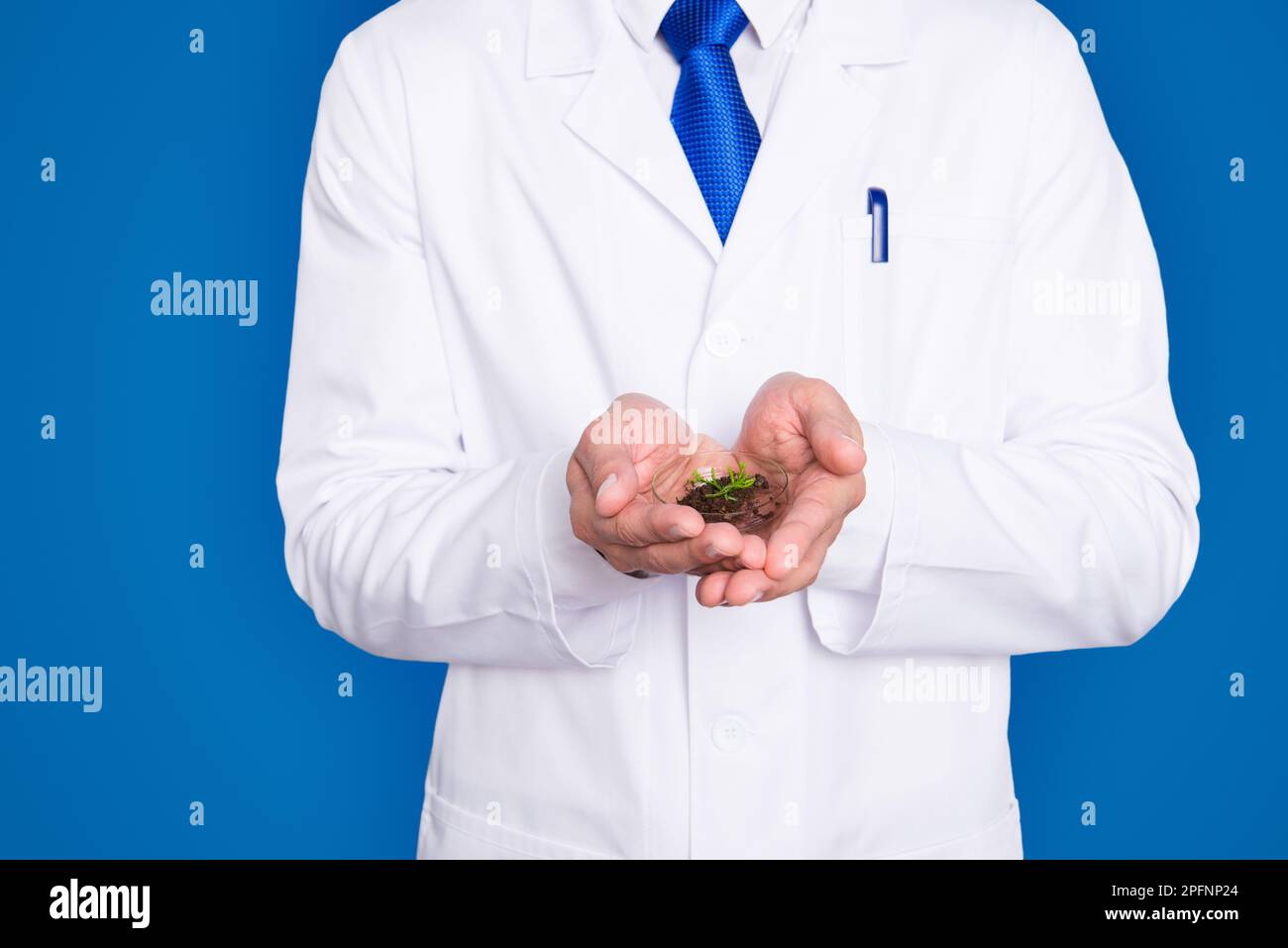 Cropped portrait of handsome biologist in white outfit with tie, showing having vial with field