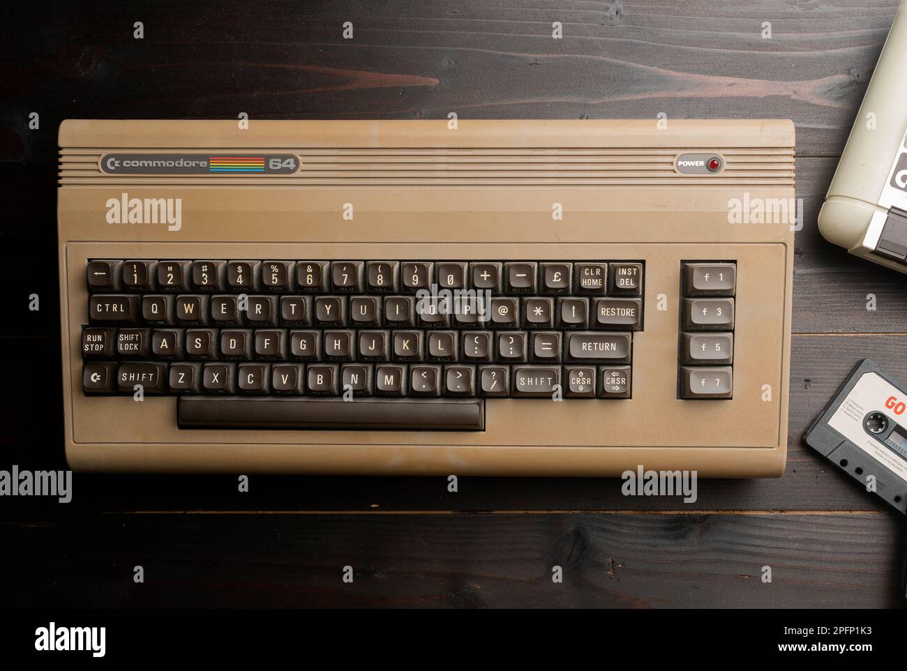 Carrara, Italy - March 18, 2023 - Commodore 64 computer with cassette player on wooden table Stock Photo