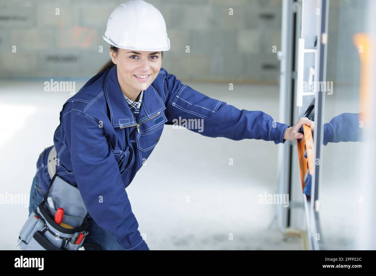 female builder using spirit level Stock Photo