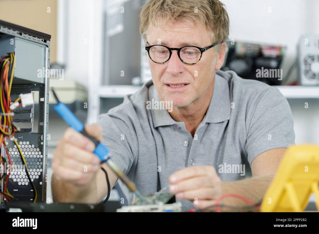 senior computer engineer working on broken console Stock Photo - Alamy