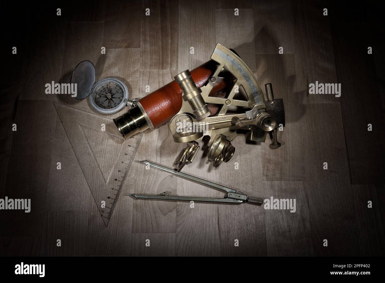 old sextant, spyglass, circle and compass lying on wooden table Stock Photo