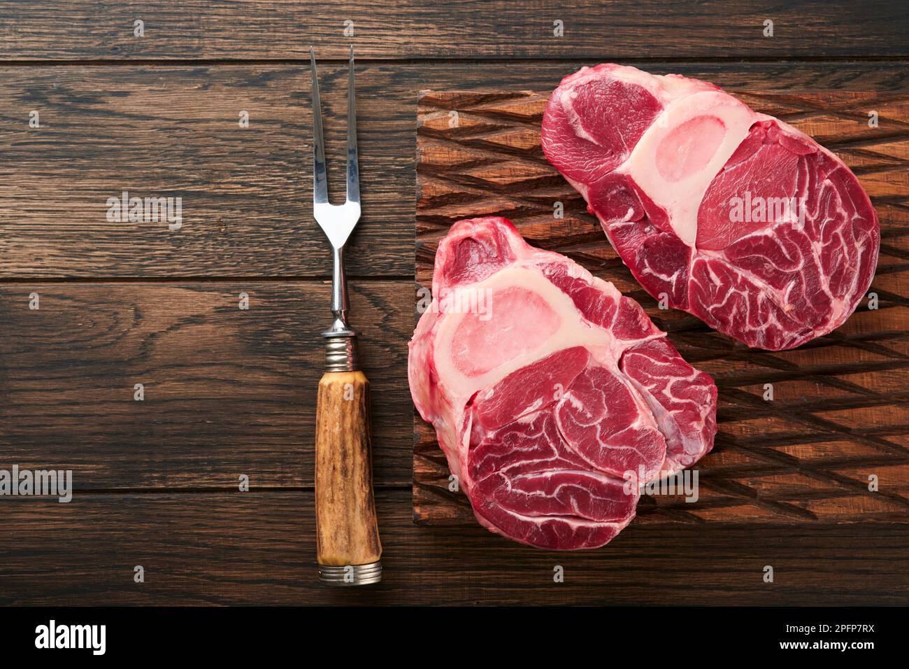 Osso Buco raw steak meat. Barbecue meat. Raw fresh cross cut veal shank and seasonings pepper, rosemary, thyme and salt on old wooden background. Beef Stock Photo