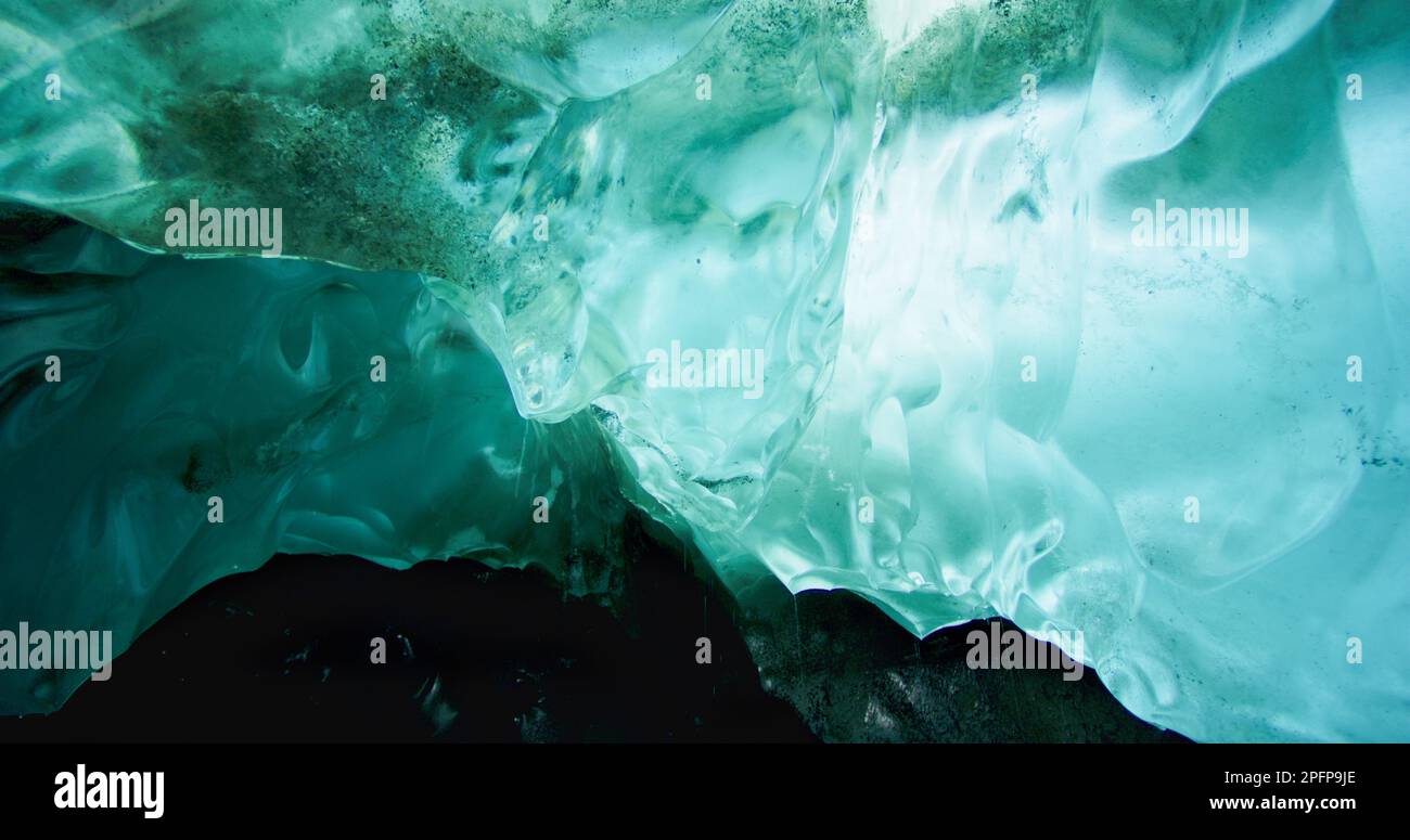 The ice under the rocks gradually melts and forms rivers. Turquoise ice. Exploring the Hidden