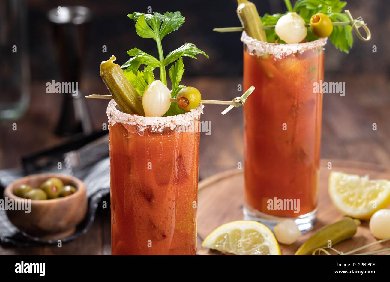 Bloody mary cocktail garnished with celery, okra, onion, olive and salt