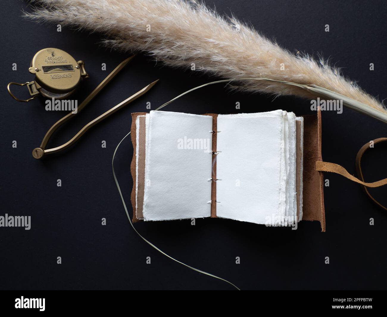 Vintage leather journal or diary on a black table with a compass next