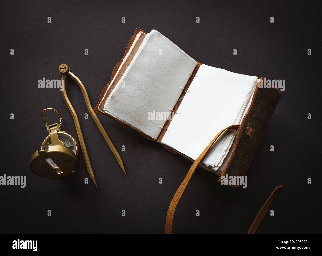 Vintage leather journal or diary on a black table with a compass next