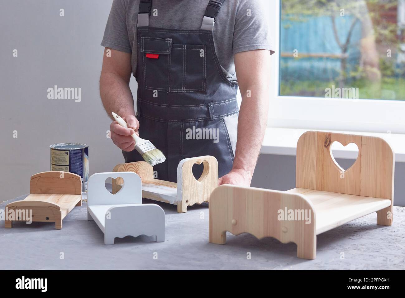 Men's hands painting baby wooden doll cots Stock Photo Alamy
