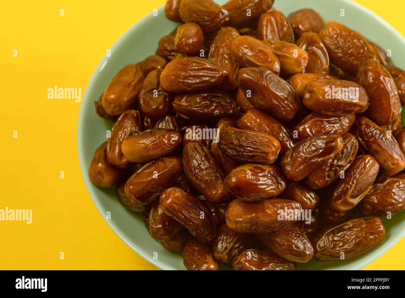 Dates. Dried date palm fruits. Healthy sweet snack food bowl. Pile of tasty dry dattes in plate